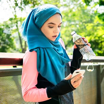 Runner drinking water and checking phone